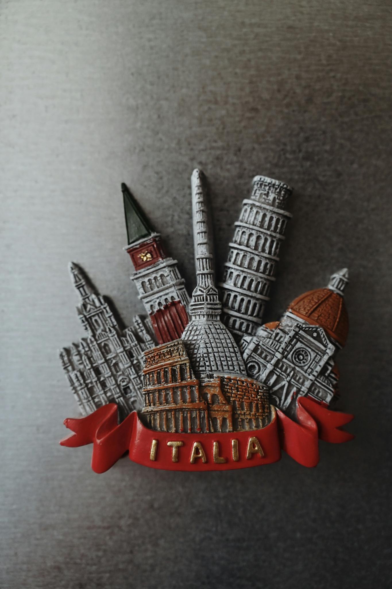 A decorative magnet showcasing Italy's famous landmarks including the Colosseum and Leaning Tower of Pisa.